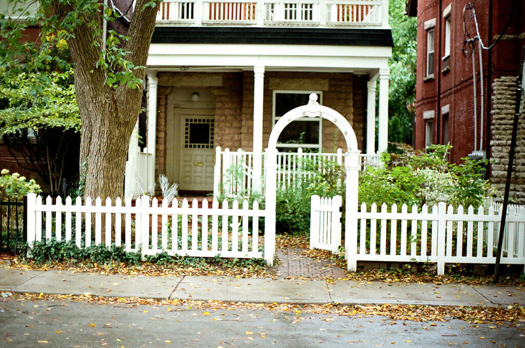 White picket fence and garden gate in front of a home — timber fence care in Canterbury