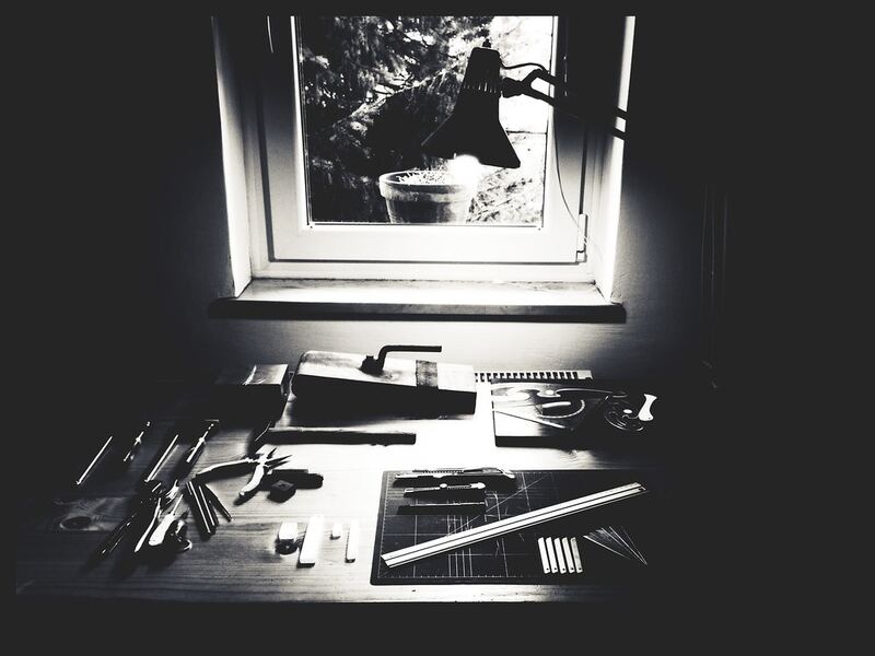 Hand tools laid out on a workbench under a lamp by a window — household repairs in Rolleston Selwyn