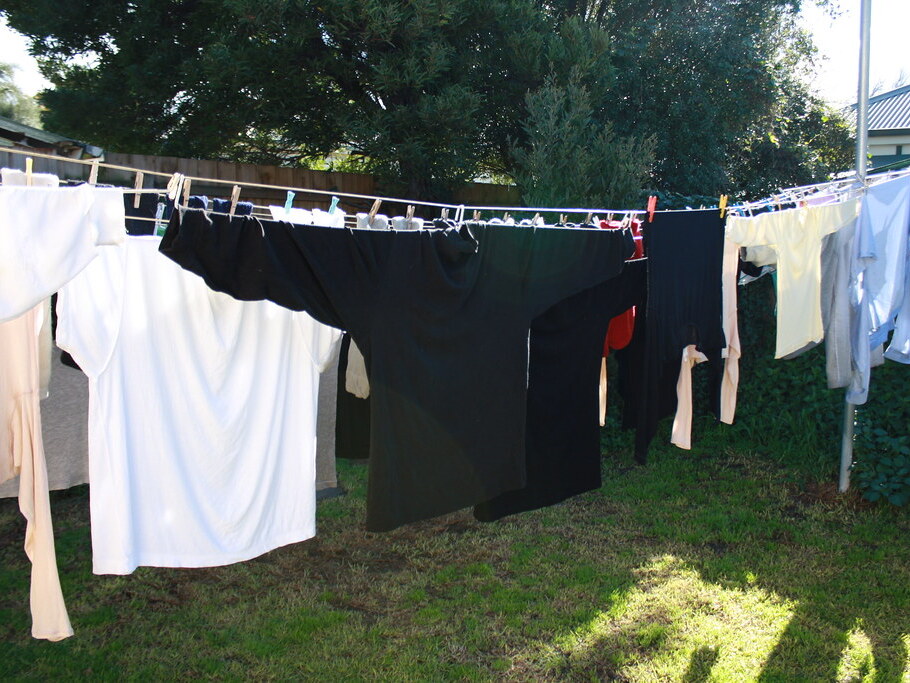Clothes drying on an outdoor washing line in a sunny suburban backyard — clothes line installation Selwyn