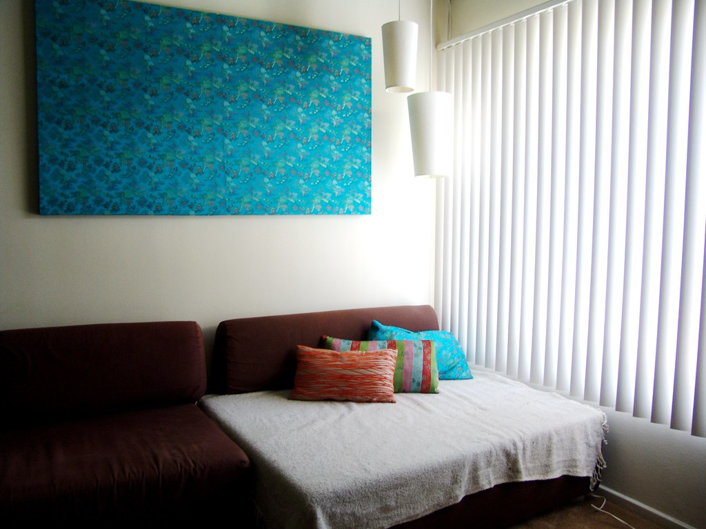 Living-room window fitted with blinds beside hung wall art — curtain rail and rod installation Rolleston