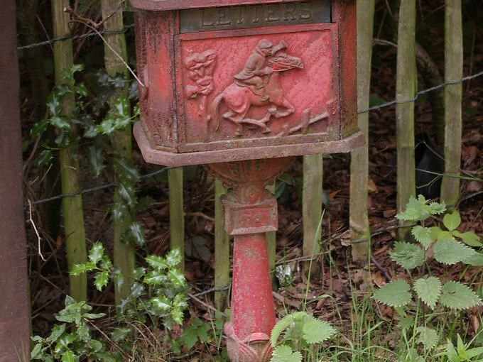Freestanding heritage-style red letterbox on a post — letterbox building in Rolleston